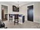 This bar features dark cabinets, complementary barstools, and a stylish chandelier, perfect for entertaining guests at 204 Ridge Dr # 12 12-1 12-2, Troy, NC 27371