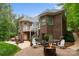 Picturesque backyard with a brick patio, spiral staircase, fire pit, and lush greenery, perfect for outdoor living at 2200 Capes Cove Dr, Sherrills Ford, NC 28673