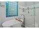 Modern bathroom featuring a soaking tub with a glass block window and a walk-in shower at 2200 Capes Cove Dr, Sherrills Ford, NC 28673
