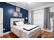 Bedroom with hardwood floors, blue accent wall and large window dressed with patterned curtains at 2200 Capes Cove Dr, Sherrills Ford, NC 28673