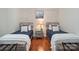 Neutral-toned bedroom with two twin beds, hardwood floors, and shiplap accent wall at 2200 Capes Cove Dr, Sherrills Ford, NC 28673