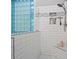 Walk-in shower featuring sleek white tile, a built-in seat, and stylish glass block accents at 2200 Capes Cove Dr, Sherrills Ford, NC 28673