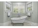 Bright bathroom featuring a soaking tub, lots of natural light from the window, and black and white tile flooring at 2414 Bay St, Charlotte, NC 28205