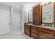 Spa-like bathroom featuring a glass-enclosed shower, dark wood cabinets, and granite counters at 2414 Bay St, Charlotte, NC 28205