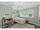 Cozy bedroom features a white metal bed, a grey desk, a light fixture, and plenty of natural light at 2414 Bay St, Charlotte, NC 28205