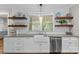 Bright kitchen with open shelving, farmhouse sink, stainless steel appliances and tile backsplash at 2414 Bay St, Charlotte, NC 28205