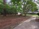 A spacious backyard with a well and a storage shed surrounded by mature trees at 3316 Mckee Rd, Charlotte, NC 28270