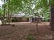 Exterior view of a brick home with backyard patio, screened porch, and surrounded by green trees at 3316 Mckee Rd, Charlotte, NC 28270