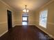 Open dining area with stylish wood-look floors, modern lighting, and bright window with backyard views at 3316 Mckee Rd, Charlotte, NC 28270