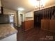 Eat-in kitchen features granite countertops, stainless steel appliances, white cabinetry, and wood-look floors at 3316 Mckee Rd, Charlotte, NC 28270