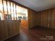 Open concept living room featuring wood paneling and an adjacent kitchen at 3316 Mckee Rd, Charlotte, NC 28270