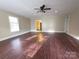 Spacious living room with wood-look floors, fan fixture, neutral paint, and doorway to the other living spaces at 3316 Mckee Rd, Charlotte, NC 28270