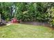 Spacious backyard with a well-kept lawn, wooden fence, and a charming red shed, creating a serene outdoor area at 4235 Howie Cir, Charlotte, NC 28205