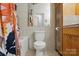 Main bathroom with a toilet and vanity with wood cabinets and neutral tile at 4235 Howie Cir, Charlotte, NC 28205