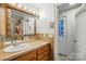 Bright bathroom with a white sink, wood cabinets and unique sconces at 4235 Howie Cir, Charlotte, NC 28205