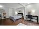 Cozy bedroom featuring a queen bed, dark wood floors, a workspace and decorative shelving at 4235 Howie Cir, Charlotte, NC 28205