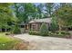 Quaint stone home featuring a pergola, lush landscaping, and a private fenced yard at 4235 Howie Cir, Charlotte, NC 28205