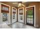 Light-filled sunroom with tile flooring, ceiling fan, and windows dressed with bamboo shades at 4235 Howie Cir, Charlotte, NC 28205