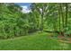 Lush backyard featuring a meticulously manicured lawn and surrounded by mature trees and greenery at 447 Merwick Cir, Charlotte, NC 28211