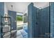 Stylish bathroom showcasing a blue mosaic tile shower, modern fixtures, and open shelving at 447 Merwick Cir, Charlotte, NC 28211