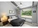 Inviting bedroom with calming gray tones, fan, and large windows showcasing the outdoor view at 447 Merwick Cir, Charlotte, NC 28211