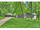 Stunning exterior of mid-century modern home with lush landscaping and gray painted facade at 447 Merwick Cir, Charlotte, NC 28211