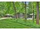 View of mid-century modern home exterior featuring gray facade and lush landscaping at 447 Merwick Cir, Charlotte, NC 28211