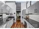 Stylish kitchen boasts stainless appliances, white cabinets, and hardwood floors with natural light at 447 Merwick Cir, Charlotte, NC 28211