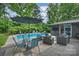 Backyard featuring a pool, patio furniture, lush greenery, and a gray exterior at 447 Merwick Cir, Charlotte, NC 28211