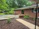 Exterior view of brick home featuring a patio and brick retaining wall at 520 Crestview Dr, Albemarle, NC 28001