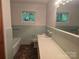 A cozy bathroom features green tile, a tub, vanity, and a large window at 520 Crestview Dr, Albemarle, NC 28001