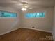 This bedroom features wood-look floors, a ceiling fan, and two large windows at 520 Crestview Dr, Albemarle, NC 28001
