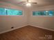 This bedroom features wood-look floors, a ceiling fan, and two large windows at 520 Crestview Dr, Albemarle, NC 28001