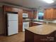 Modern kitchen featuring hardwood cabinets, updated appliances, and granite countertops at 520 Crestview Dr, Albemarle, NC 28001