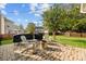 Charming backyard with a brick patio, fire pit, and barbecue grill, ideal for relaxation and outdoor gatherings at 6119 Castlecove Rd, Charlotte, NC 28278