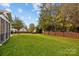 Expansive backyard with a well-manicured lawn, mature trees, and a wooden fence, offering privacy and space at 6119 Castlecove Rd, Charlotte, NC 28278