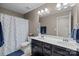 Well-lit bathroom with dual sinks, vibrant polka dot shower curtain, and vanity offers functionality and style at 6119 Castlecove Rd, Charlotte, NC 28278