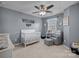 Serene Bedroom with gray walls, white crib, and a comfy glider, offering a peaceful and stylish environment at 6119 Castlecove Rd, Charlotte, NC 28278