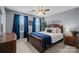 Inviting primary bedroom featuring a dark wood bed frame, blue accents, and ample natural light at 6119 Castlecove Rd, Charlotte, NC 28278