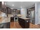 Modern kitchen with dark wood cabinets, granite countertops, and stainless steel appliances at 6119 Castlecove Rd, Charlotte, NC 28278