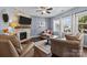 Comfortable living room featuring a stone fireplace, ceiling fan, and lots of natural light at 6119 Castlecove Rd, Charlotte, NC 28278