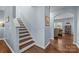 A classic staircase with wooden steps and white risers leads to the upper level at 6119 Castlecove Rd, Charlotte, NC 28278
