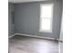 This simple bedroom features a new modern floor, neutral colored walls and natural light from a window at 614 Goldsboro Ave, Statesville, NC 28677