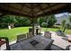 Covered outdoor patio with dining set and grill, perfect for backyard relaxation and entertaining at 6309 Crosshall Pl, Waxhaw, NC 28173