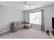 Cozy bedroom featuring a gray couch and well-lit window at 6309 Crosshall Pl, Waxhaw, NC 28173