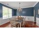 Traditional dining room featuring chair-rail detail, blue walls, hardwood floors, and a chandelier over the dining table at 6309 Crosshall Pl, Waxhaw, NC 28173