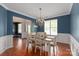 Traditional dining room with chair-rail, a chandelier, hardwood floors, and a view of the front door at 6309 Crosshall Pl, Waxhaw, NC 28173