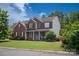 Beautiful two-story brick home with black shutters and an inviting front porch, perfect for enjoying quiet moments at 6309 Crosshall Pl, Waxhaw, NC 28173