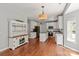 Open-concept kitchen featuring white cabinets, granite countertops, stainless steel appliances, and hardwood floors at 6309 Crosshall Pl, Waxhaw, NC 28173