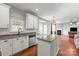Bright kitchen with white cabinets, granite countertops, a stainless steel dishwasher, and hardwood floors at 6309 Crosshall Pl, Waxhaw, NC 28173